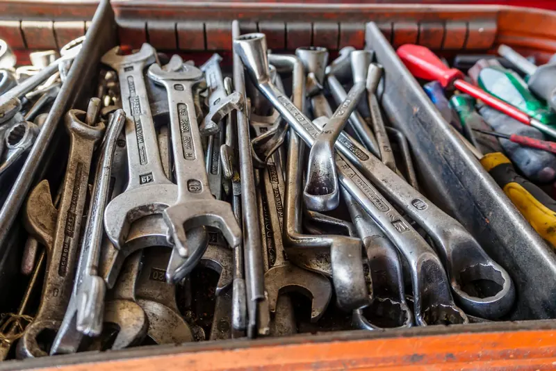 A tray filled with a jumble of wrenches and screwdrivers